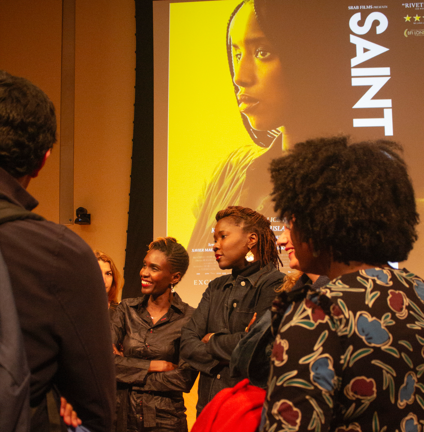 Rokhaya Diallo and Alice Diop stand next to each other as audience member converse with them.